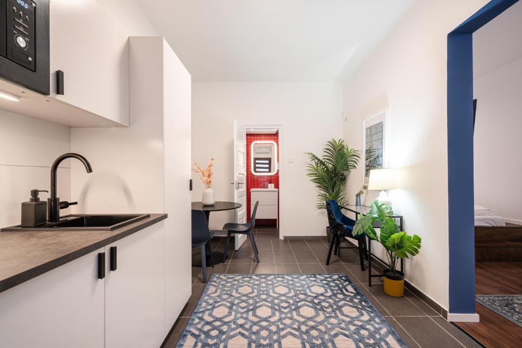 R10 - Boutique Apartments, Best location by BQA في بودابست: مطبخ وغرفة معيشة مع حوض وطاولة