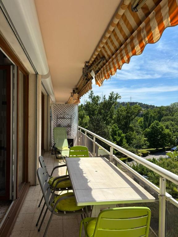 un patio avec une table et des chaises sur un balcon dans l'établissement Aix en Provence, dans grande résidence arborée, appartement de 80m2, à Aix-en-Provence
