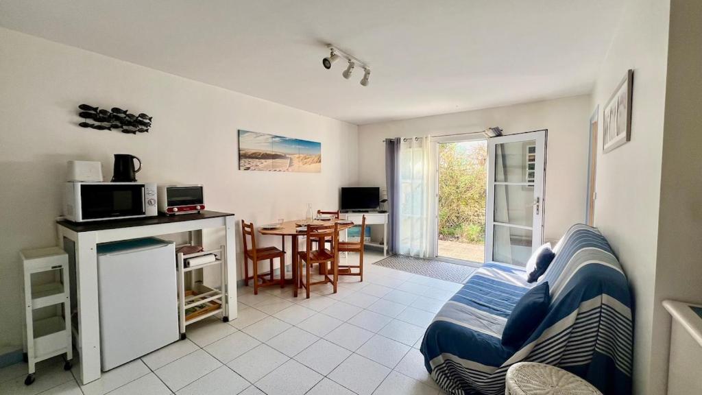 un salon avec un canapé et une cuisine avec une table dans l'établissement 100 L'Orneau - Plain-pied avec terrasse, idéalement situé, à Saint-Martin-de-Ré