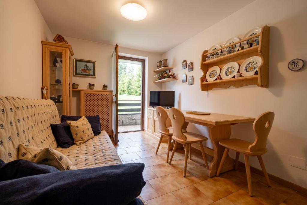 una sala de estar con una mesa y sillas en Casa Lugli by go new location, en Cavalese