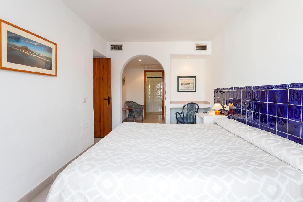 a bedroom with a large white bed with blue tiles at Doña Pakyta in San José
