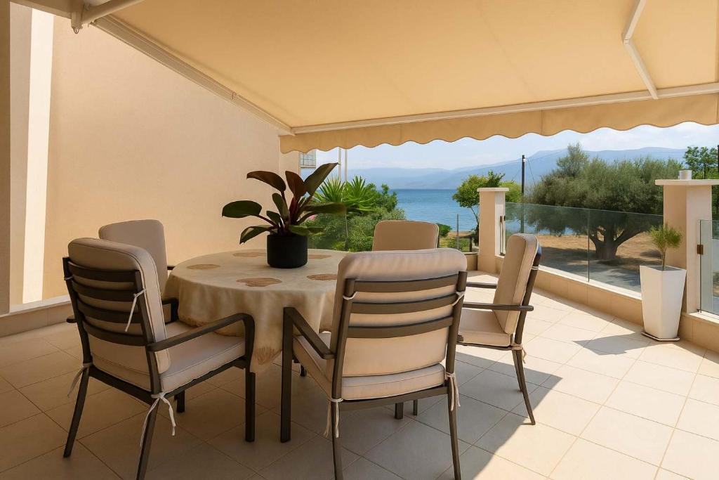 a dining room table and chairs with a view of the ocean at La Casa Rosa Seaside Getaway in Marathiás