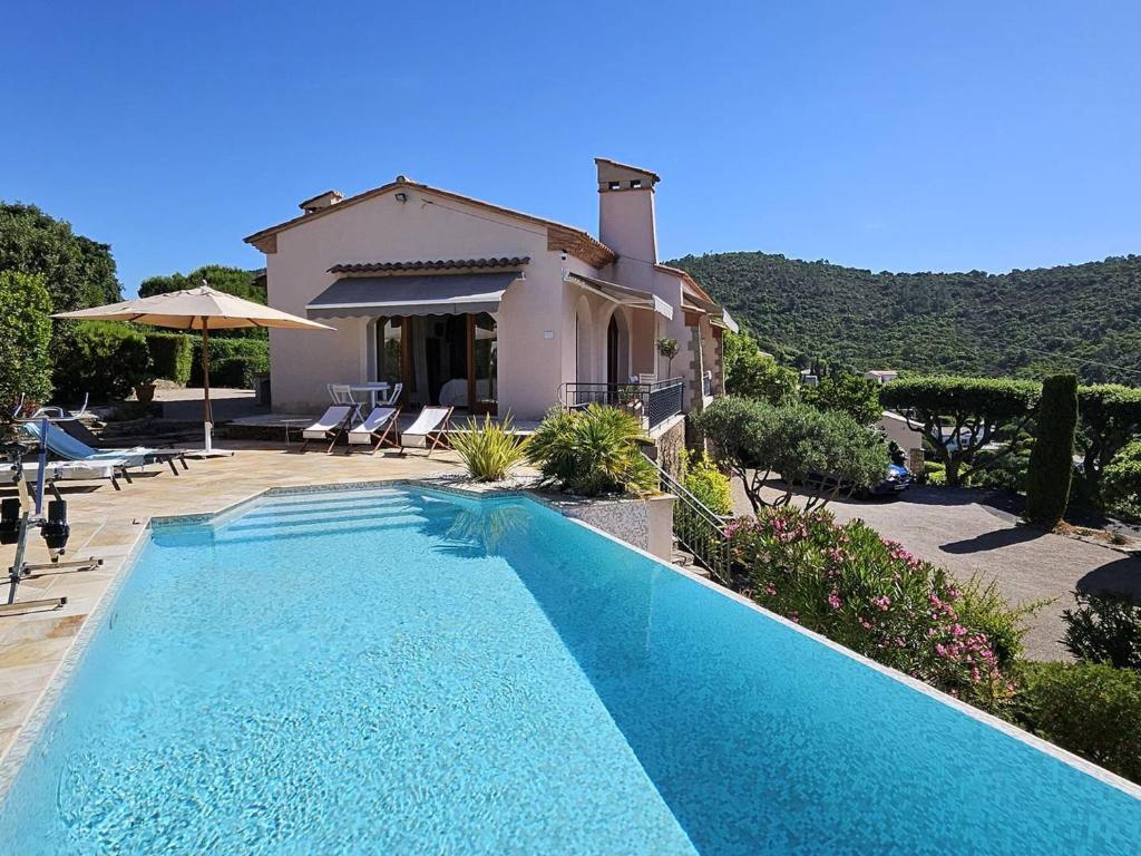 une piscine devant une maison dans l'établissement Villa avec piscine privée, climatisation et parking, proche plages aux Issambres - FR-1-768-108, à Saint-Peïre-sur-Mer