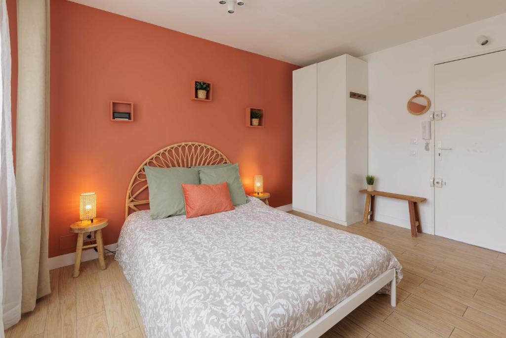 une chambre avec un lit avec un mur orange dans l'établissement Une Escapade au Vieux Port, à Marseille