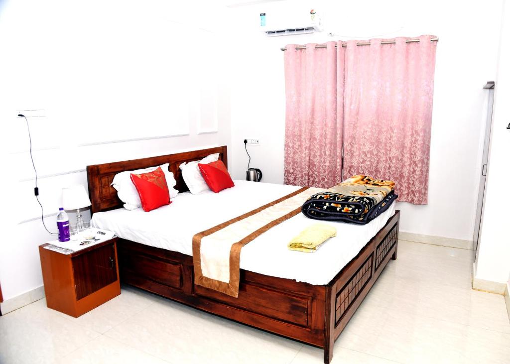 a bedroom with two beds with red pillows at Hotel Atithi Grand, Gobarsahi in Muzaffarpur