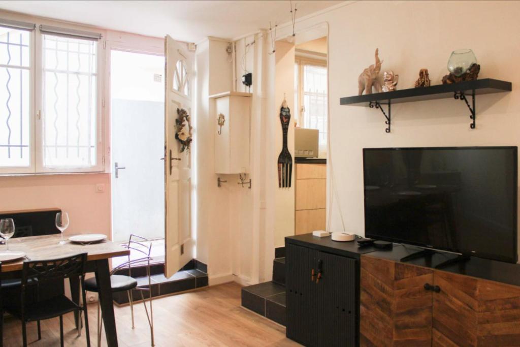 un salon avec une télévision et une salle à manger dans l'établissement Comfortable apartment in the heart of Paris, à Paris