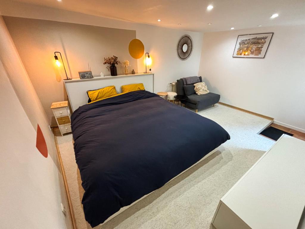 - une chambre avec un grand lit noir et une chaise dans l'établissement La Dépendance d'Obernai - Parking Gratuit - Centre Ville - Commerces à proximité, à Obernai