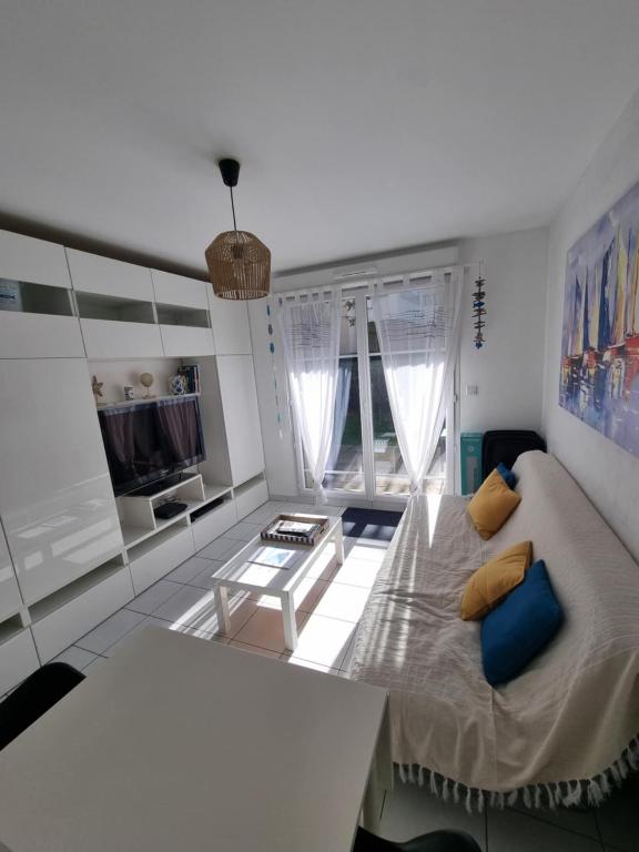 un salon avec un canapé et une table dans l'établissement Coquillages et crustacés à Cayeux sur mer, à Cayeux-sur-Mer