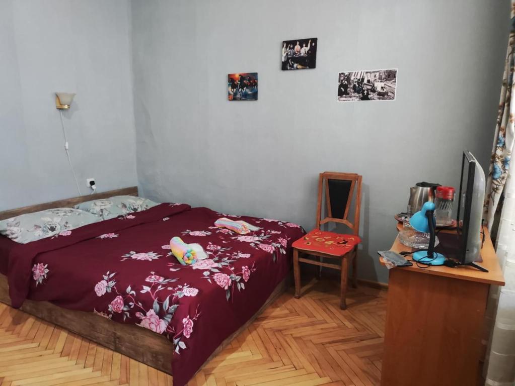 a bedroom with a bed and a desk with a tv at apartment Jessi on Marjanishvili in Tbilisi City