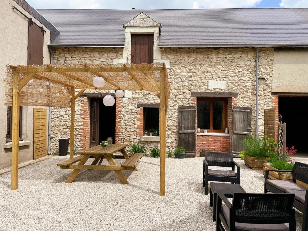a wooden picnic table and benches in front of a building at Gîte à Oisly près des Châteaux de la Loire avec Parking et Animaux Bienvenus - FR-1-491-469 in Oisly