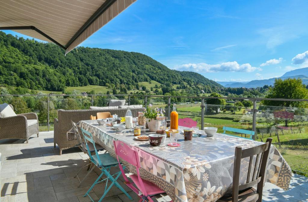 einen Tisch auf der Terrasse mit Bergblick in der Unterkunft La Maison Dauphinoise in Saint-Bueil