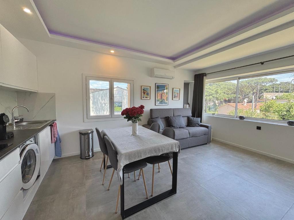 une cuisine et un salon avec une table et un canapé dans l'établissement Luma - Logement Climatisé Proche Centre & Plages, à Saint-Tropez