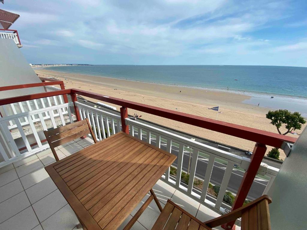 un balcon avec un banc en bois donnant sur la plage dans l'établissement Nid Douillet pour 2, face à la mer, à La Baule