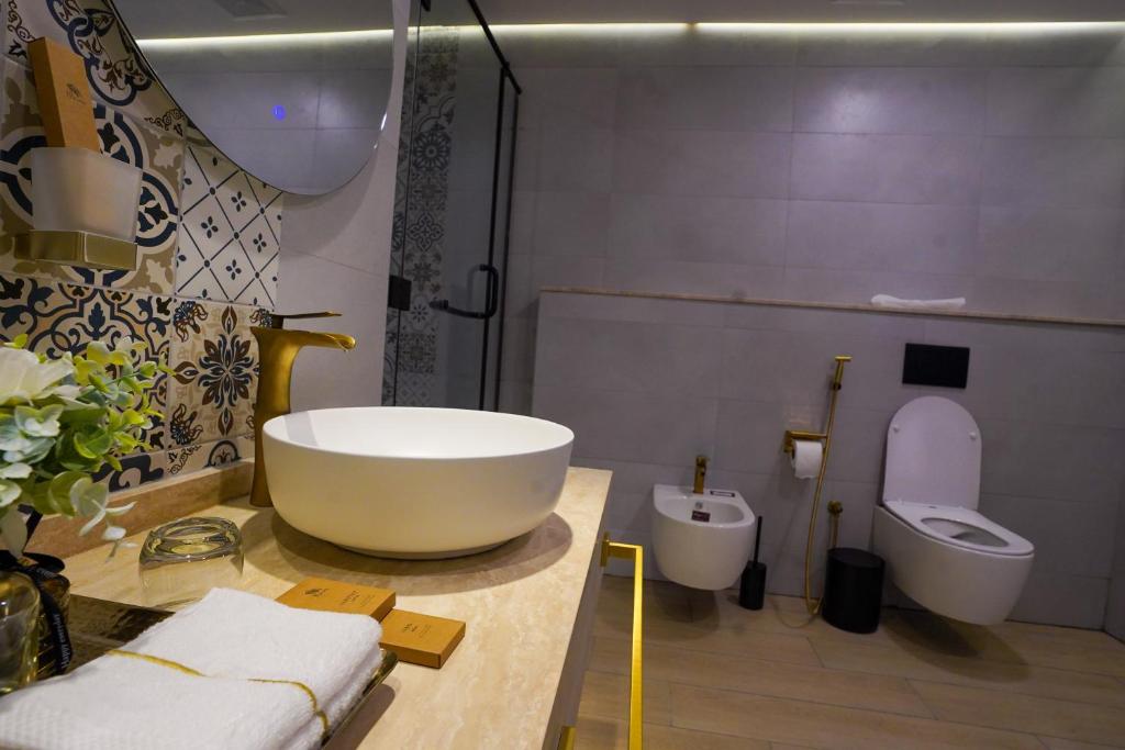 a bathroom with a large tub and a toilet at Al Marmoom Oasis Luxury Experiential Desert Resort in Dubai