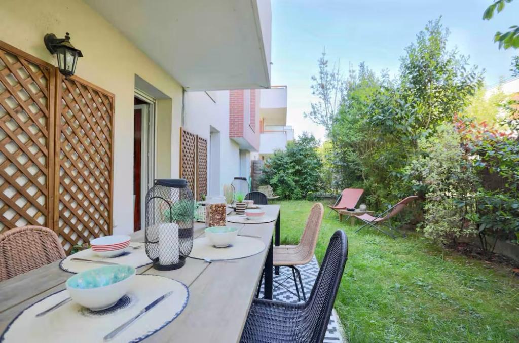 - une table avec des bols et des assiettes sur une terrasse dans l'établissement Appartement 6 personnes jardin parking, à Montévrain