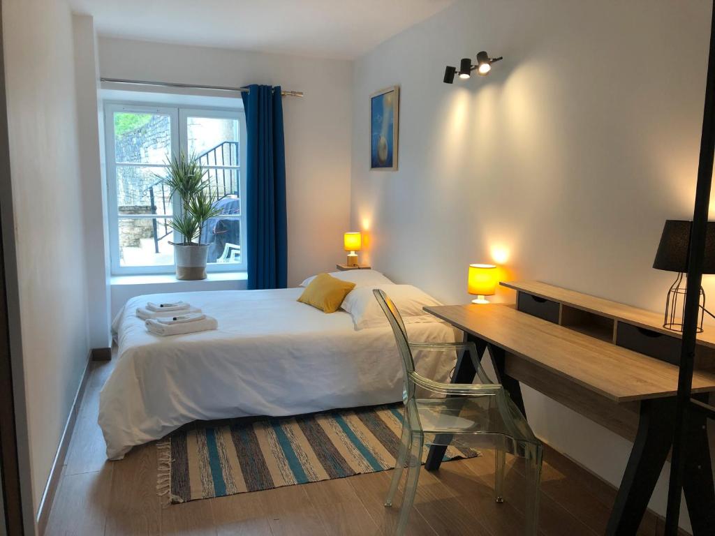 une chambre avec un lit, un bureau et une fenêtre dans l'établissement Gîte de l'Abbaye chambre simple, à Rollainville