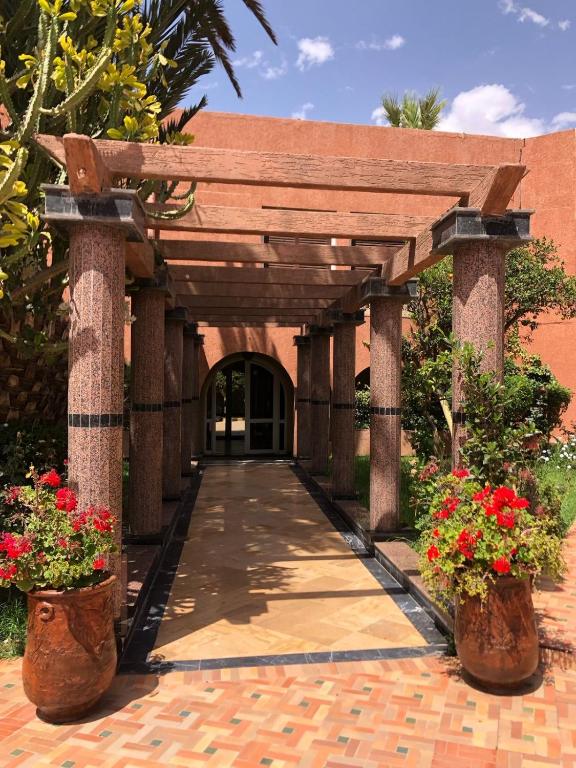 une entrée à un bâtiment avec deux plantes en pot dans l'établissement Tiznit Hotel, à Tiznit