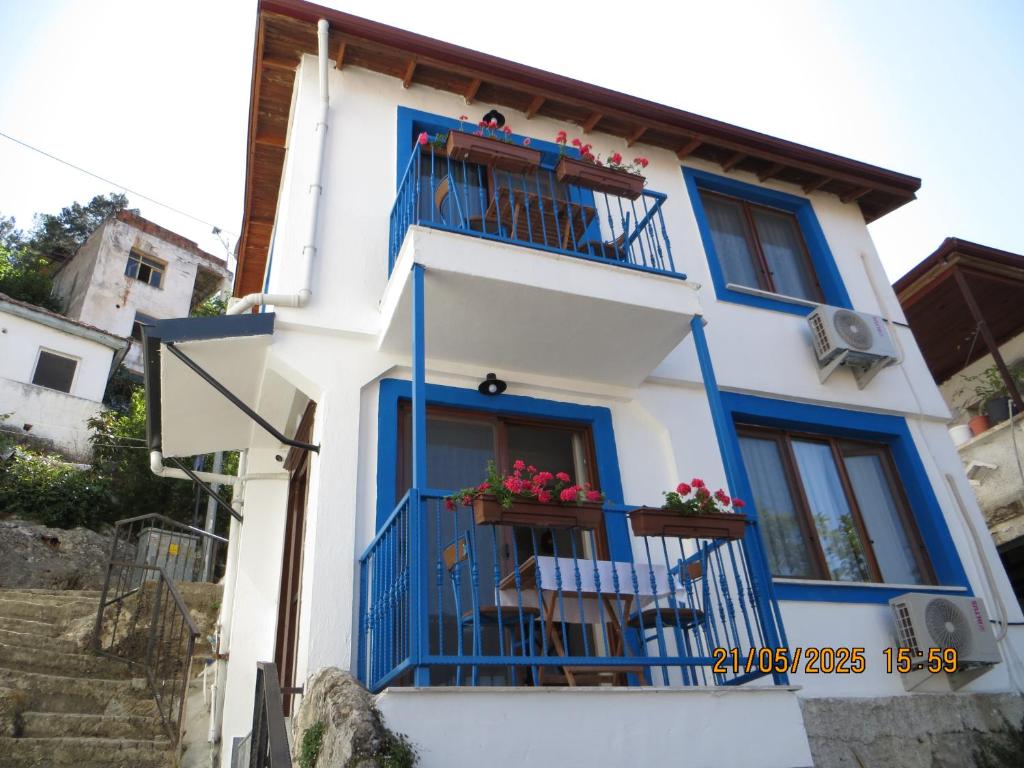 a blue and white house with a balcony at Stella Blu Apartments in Fethiye