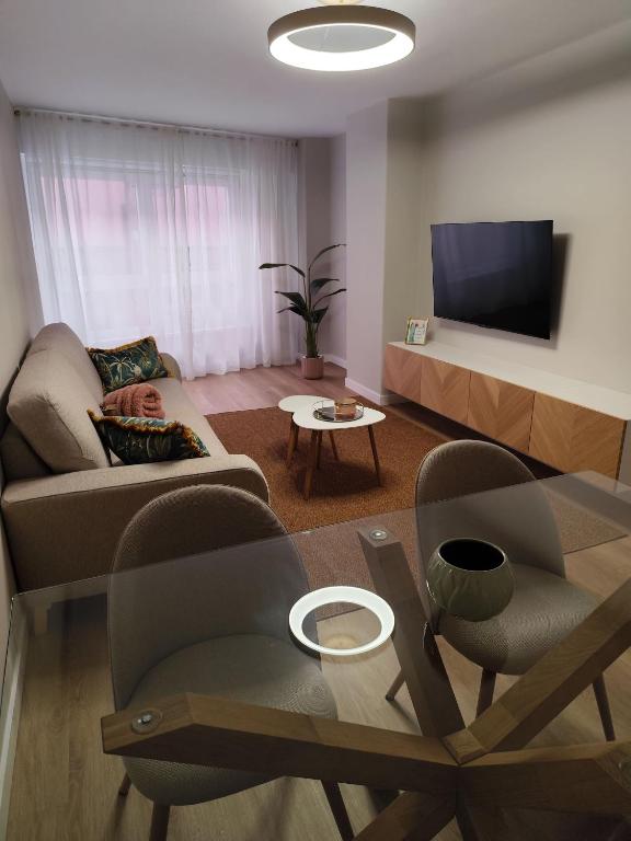 a living room with a couch and a tv at Cangas con encanto in Cangas de Morrazo