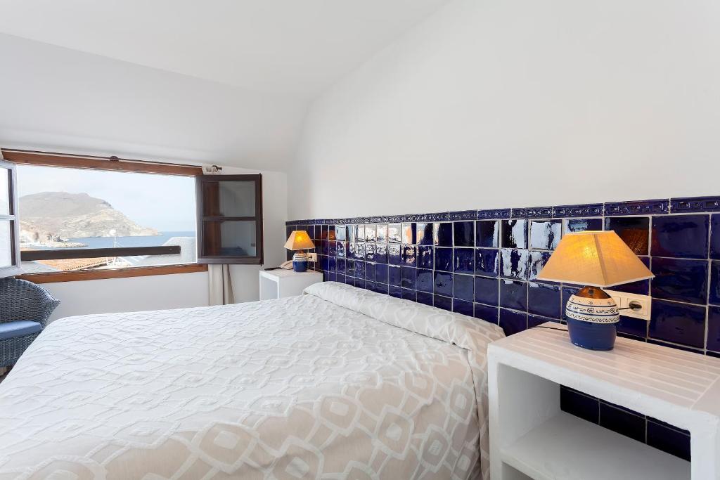 a bedroom with a white bed and a window at Doña Pakyta in San José