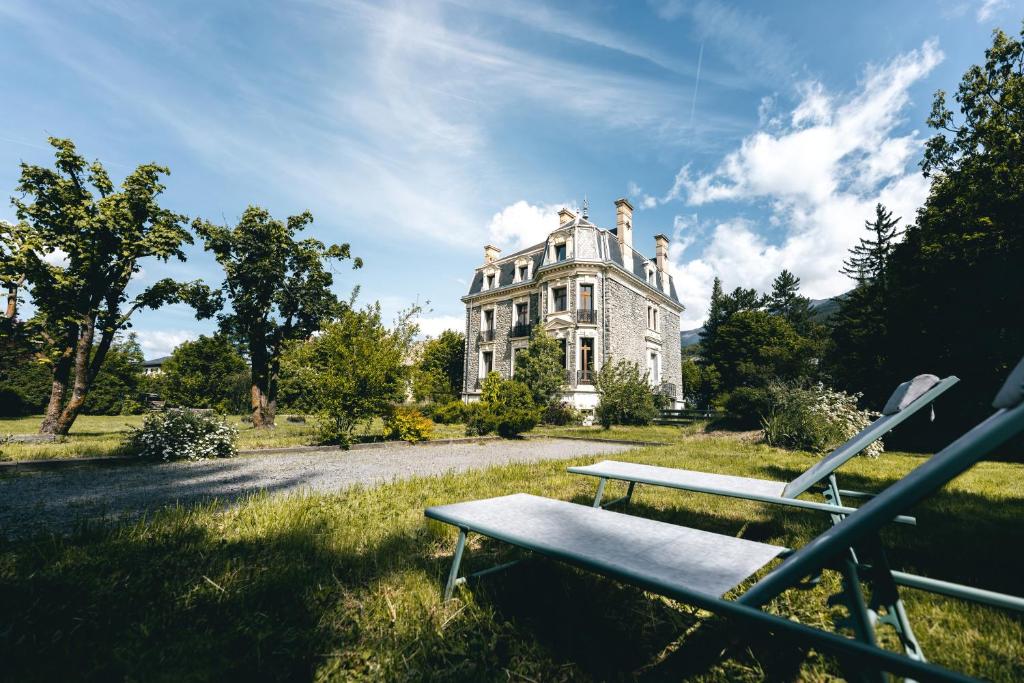 une vieille maison avec un banc devant elle dans l'établissement Appartement 130m2 dans villa Mexicaine, à Barcelonnette