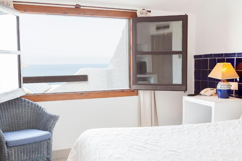 a bedroom with a window and a bed and a chair at Doña Pakyta in San José