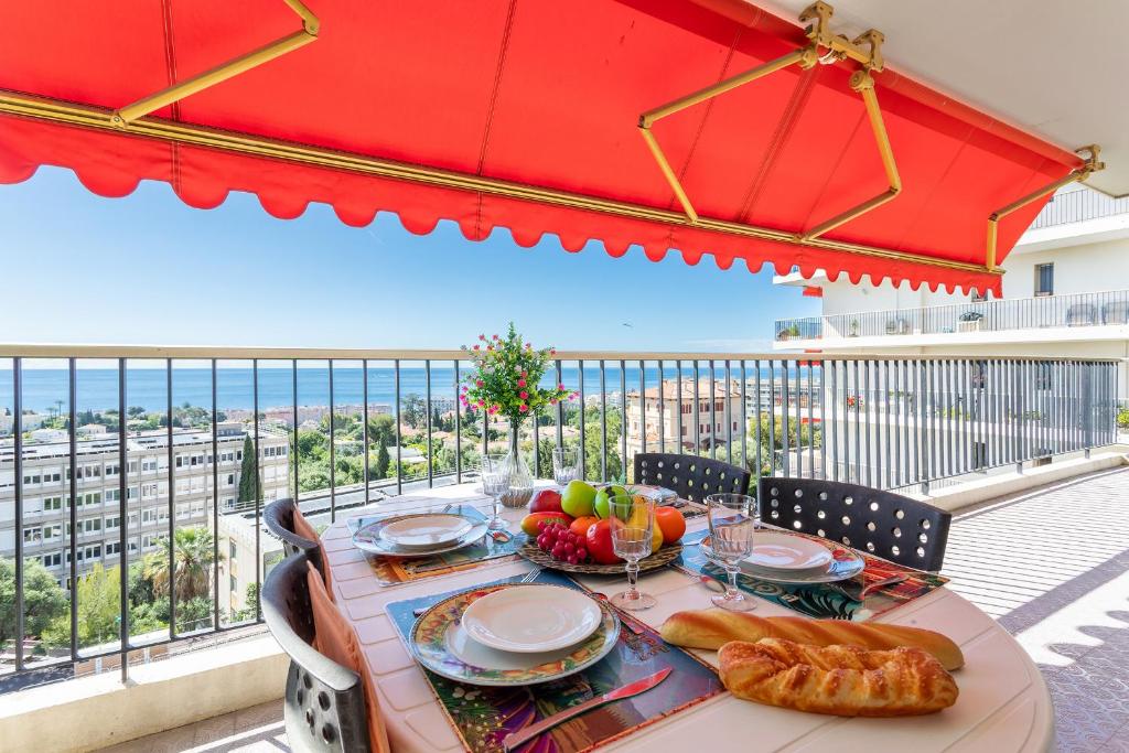 - une table avec une assiette de nourriture sur le balcon dans l'établissement ALTAIR AP4466 by RIVIERA HOLIDAY HOMES, à Nice