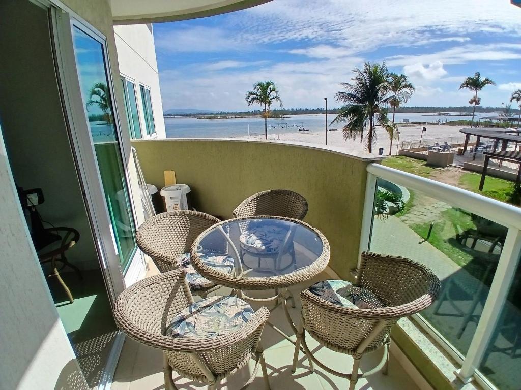 un balcone con tavolo e sedie e vista sulla spiaggia di Golden Lake - Lazer e Conforto ad Arraial do Cabo