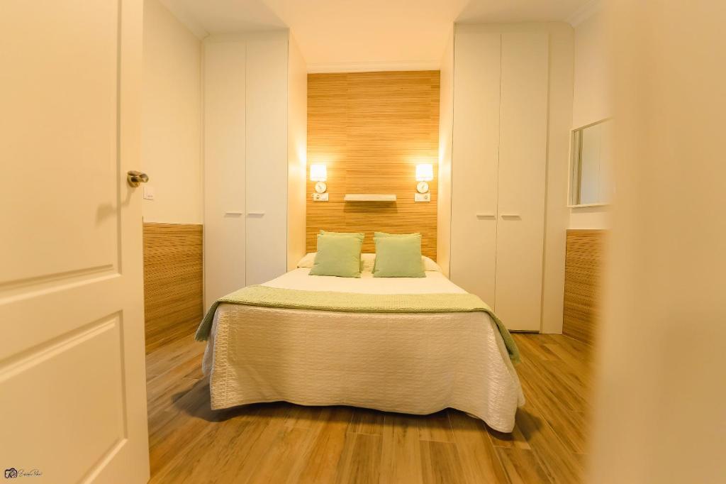 a bedroom with a bed with two pillows on it at Apartamento Reyes Católicos Conil in Conil de la Frontera