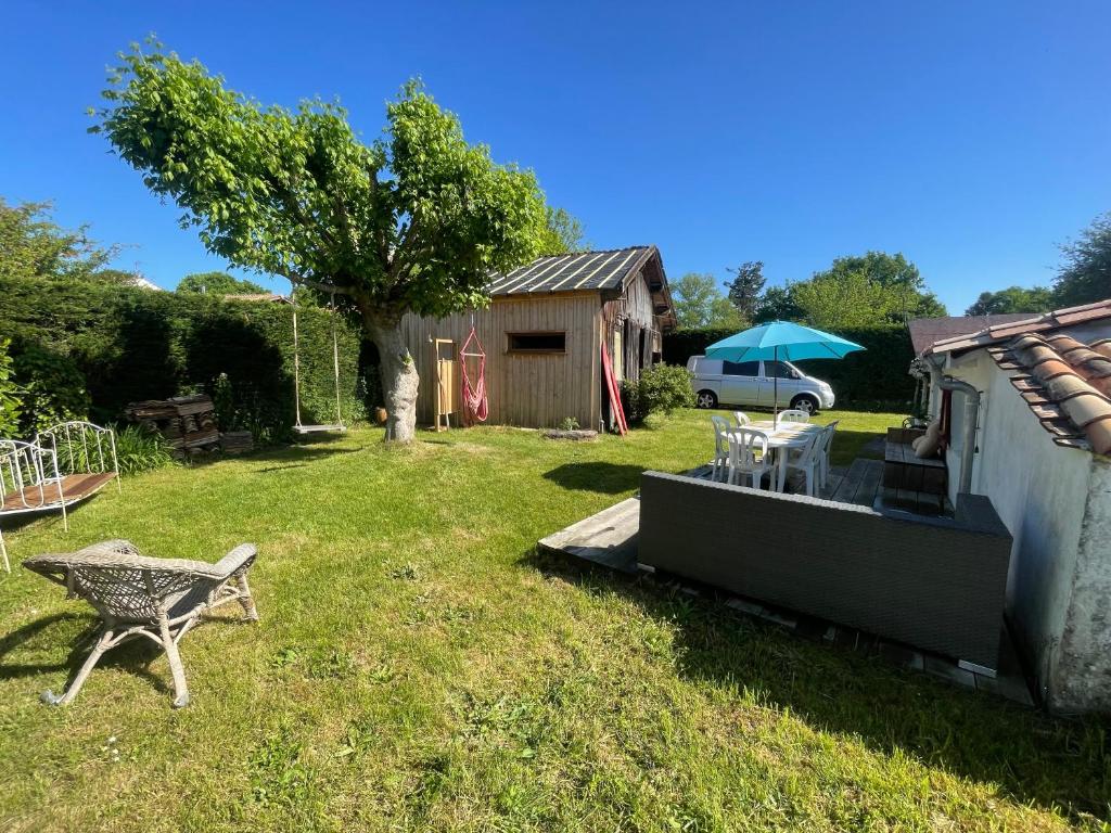 une cour avec un banc, une table et une maison dans l'établissement Paloma Blanca, à Naujac-sur-Mer