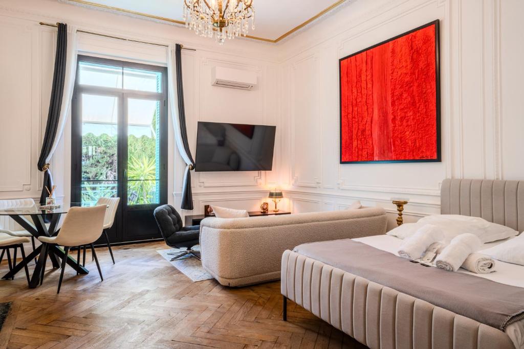 - un salon avec 2 lits et une télévision dans l'établissement Appartement Belle Époque cœur de ville -AC-, à Nice