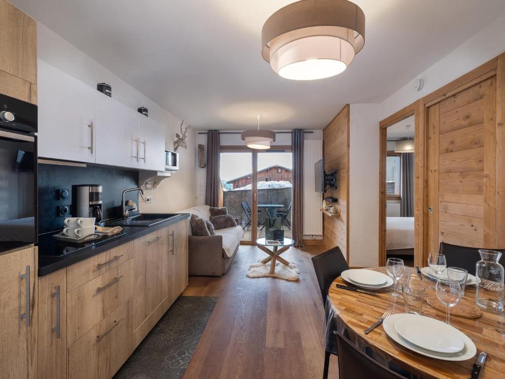 eine Küche mit einem Tisch und ein Wohnzimmer in der Unterkunft Appartement charmant 4 pers, piste proche, parking, Les Saisies - FR-1-809-13 in Les Saisies