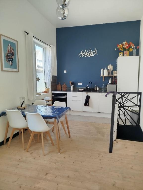 une salle à manger avec une table et des chaises et une cuisine dans l'établissement Escale à Bray Dunes, à Bray-Dunes
