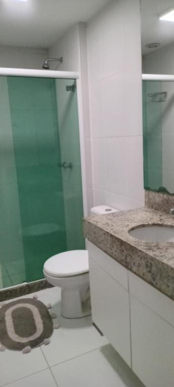 a bathroom with a toilet and a glass shower at Apartamento confortavel a cinco minutos da praia de icarai in Niterói