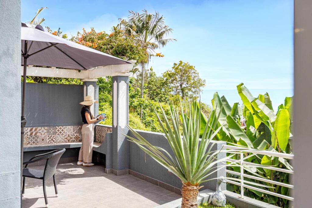 a woman standing on the balcony of a house at Casa da Fonte by YOUR KEY - 1st floor house in Ribeira Brava