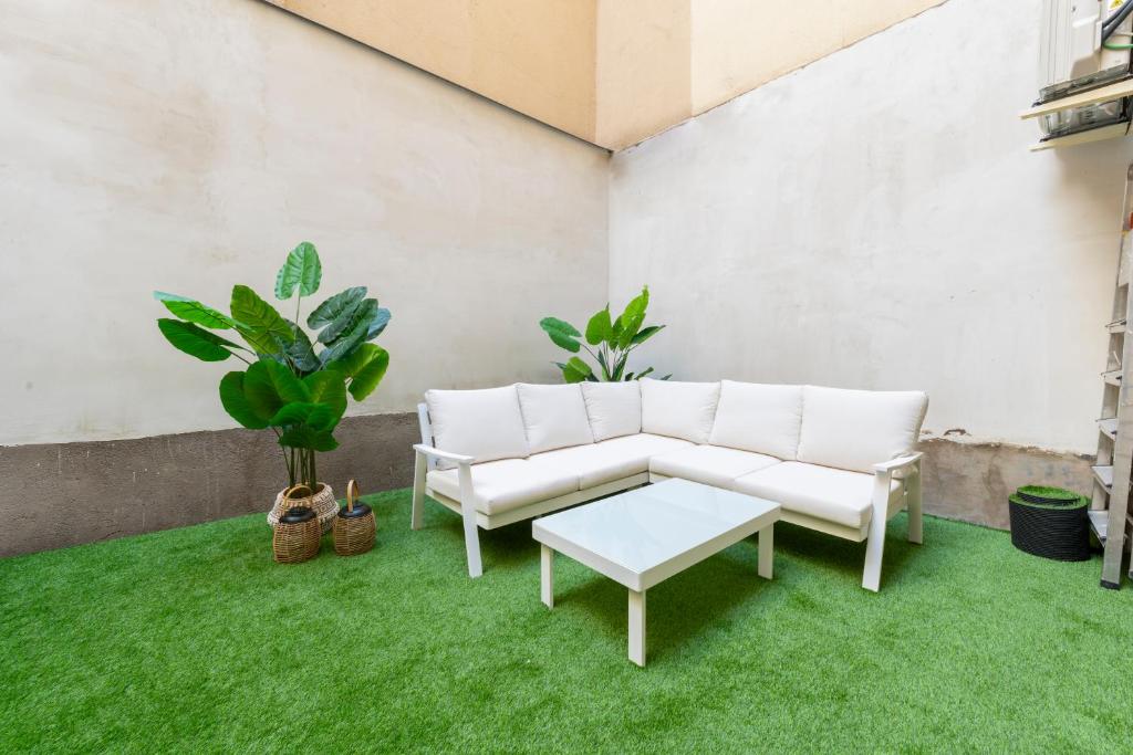 ein Wohnzimmer mit weißen Möbeln und grünem Gras in der Unterkunft Apartamento de 1 dormitorio cerca de Plaza España-Madrid Temporal PEZ14 in Madrid