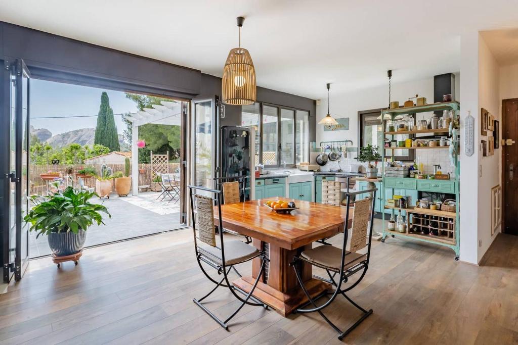 une cuisine avec une table et des chaises en bois dans l'établissement Propriété vue mer avec jardin et terrasse proche port et calanques, à La Ciotat