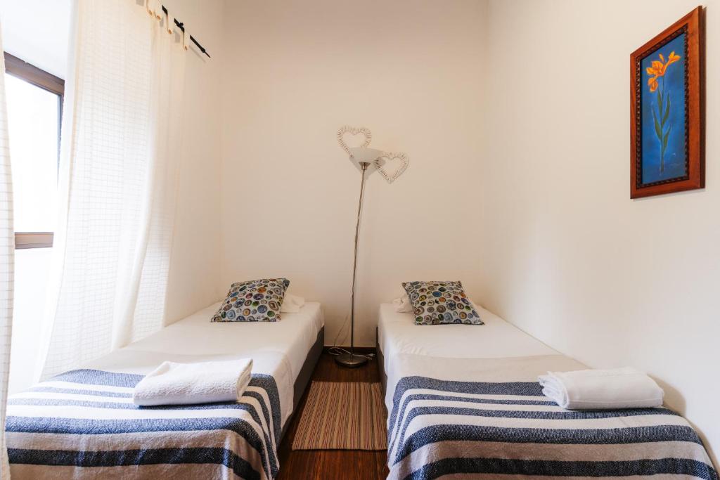 Zimmer mit 2 Betten und einer Stehlampe in der Unterkunft Apartamento 1 - Fundação de Veiros in Veiros