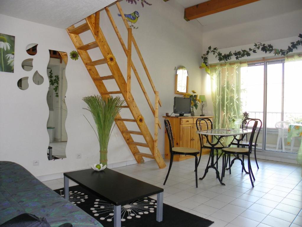 - un salon avec un escalier, une table et des chaises dans l'établissement Appartement avec chambre et mezzanine à proximité de la mer, au Cap d'Agde