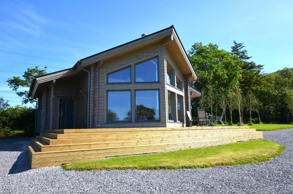 a small house with a large window and stairs at Ty Log Llansteffan in Llanstephan