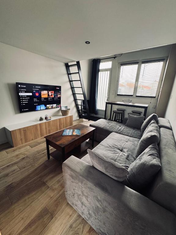 un salon avec un canapé et une table dans l'établissement Maison moderne et cosy aux Sables d Olonne, à Les Sables-dʼOlonne