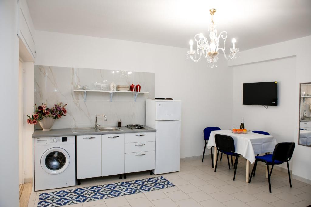 a kitchen with a table and a sink and a washing machine at Appartamento Centrale Scalea in Scalea