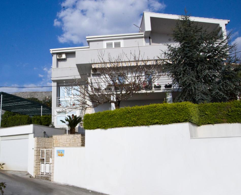 Una casa blanca con hiedra a un lado. en Apartment Pčelica Maja, en Podstrana