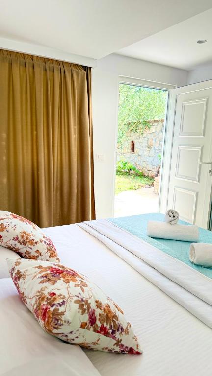 a bedroom with a bed with pillows and a window at Rida Village Ksamil Island in Ksamil
