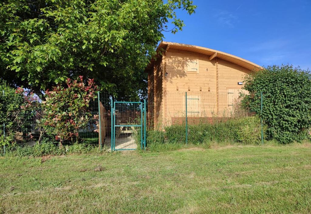 a fence in front of a building with a gate at Le chalet des Sarteaux in Ville-sur-Lumes
