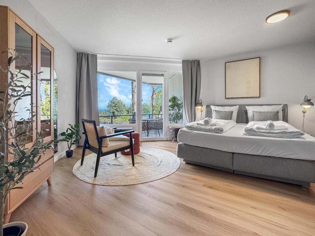 a bedroom with a bed and a chair and a window at Design-Apartment mit Meerblick in Travemünde