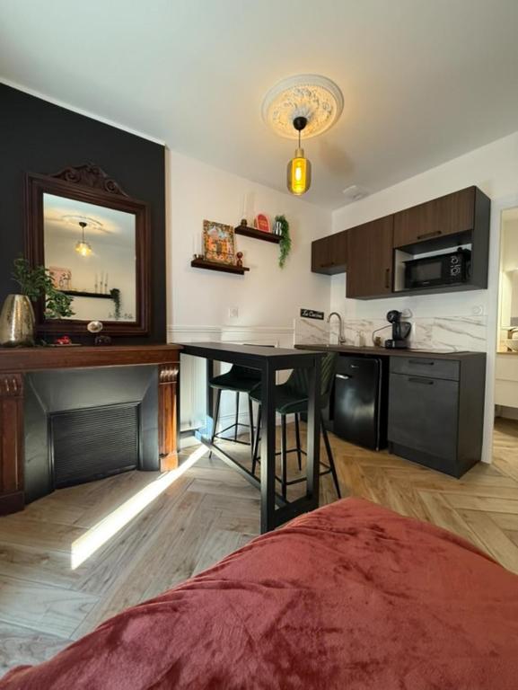 - une cuisine avec une table et un miroir dans la chambre dans l'établissement Le Little Italy, à Cholet