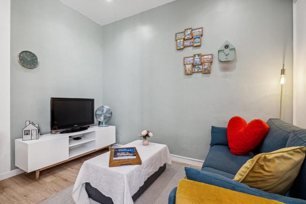 un salon avec un canapé bleu et une télévision dans l'établissement Appartement La Citadine - Welkeys, à Antibes