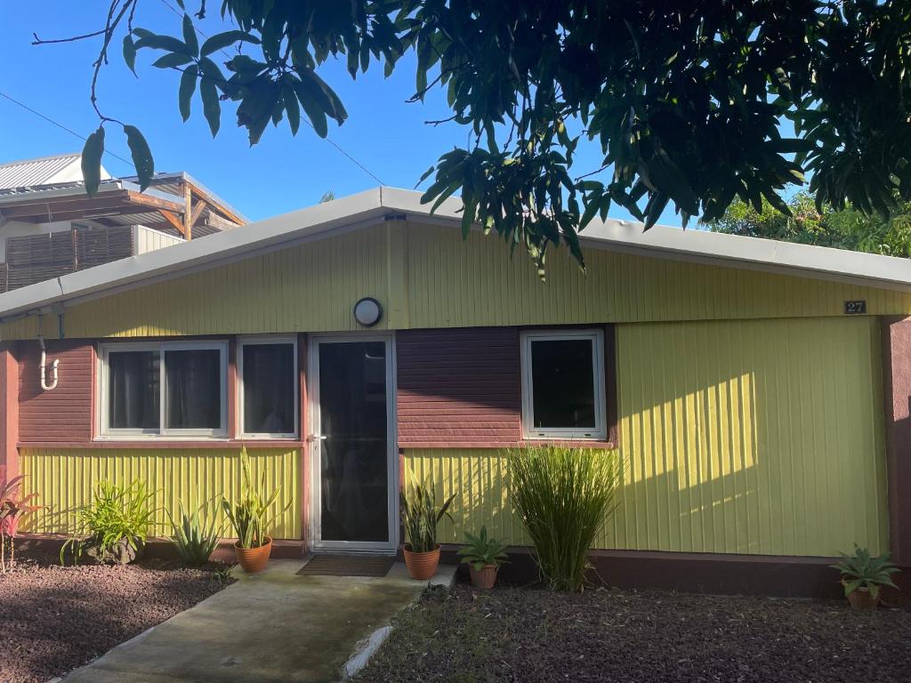 Una casa verde y amarilla con plantas delante. en Casa Valencia, proche de toutes commodités, en Saint-Pierre