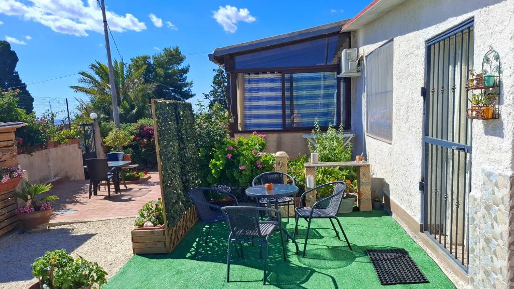a small backyard with a table and chairs on the grass at Casa Mariella in Sciacca